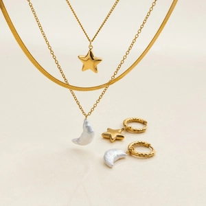 Detail of gold layered necklaces and star moon earrings set with baroque pearl