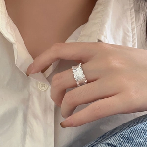 Irregular textured 925 sterling silver minimalist ring worn on hand with white shirt