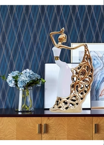 Close-up of golden hollowed-out floral pattern on a white ceramic dancer statue