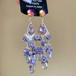 Macro shot of 925 silver fringe earrings with teardrop crystals and sparkling rhinestones