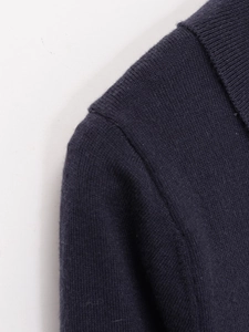 Dettaglio della maglia fine e delle cuciture su un maglione polo blu navy da donna