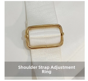 Macro shot of a golden metal adjustment ring on a white woven shoulder strap