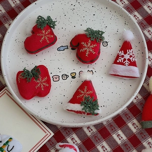 Macro shot of felt Christmas accessory set with gold embroidery and red plaid fabric