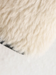 Close-up of soft creamy white faux fur texture showing fluffy high-density plush fibers