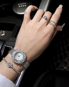 Dettaglio orologio di lusso da donna con lunetta di strass e bracciali coordinati