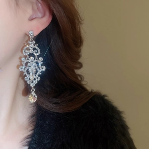 Macro detail of luxury water drop earrings featuring sparkling crystals on a silver setting
