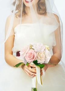 Wedding bridal bouquet featuring artificial pink and white roses with green leaves