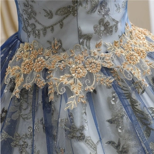 Detailed close-up of gold lace floral embroidery and sequins on navy mesh evening dress