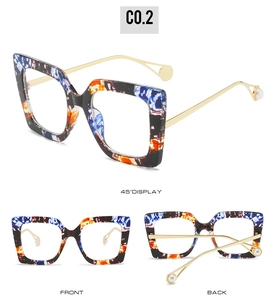 Detail of square glasses frame with blue and orange textures, gold temples, and pearl ends