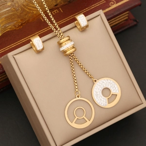 Detailed shot of gold jewelry set with white enamel star and crystal keyhole charms