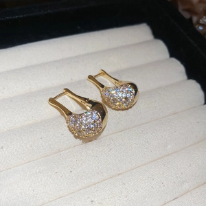 Gros plan détaillé des boucles d'oreilles en U dorées avec incrustation de zircone