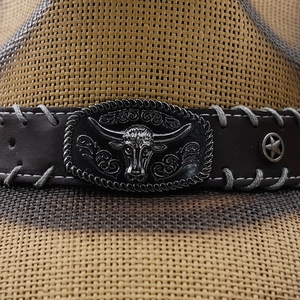 Macro di cappello da cowboy in paglia con fascia in pelle e fibbia a testa di toro in metallo