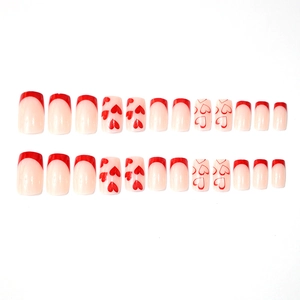 French tip press-on nails set with red hearts and polished nude base for Valentine's Day
