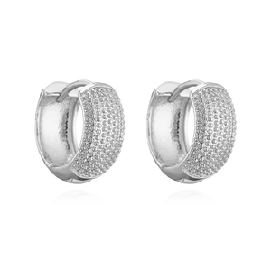Boucles d'oreilles huggie argentées avec zircons micro-pavé sur fond blanc pur