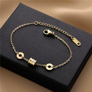 Gros plan d'un bracelet doré avec pendentif ressort sur boîte à bijoux avec ruban de soie