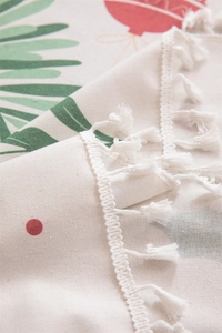 Macro view of Christmas floral prints on beige cotton linen fabric with white tassel edge