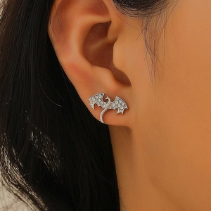 Gros plan d'une boucle d'oreille dragon en argent ornée de zircons blancs étincelants