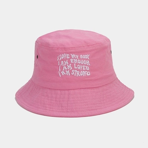 Détail d'un chapeau bob rose en coton avec broderie blanche et œillet d'aération en métal