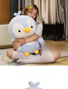 Detail of soft penguin plush toy filled with down cotton held by a person in a cozy setting