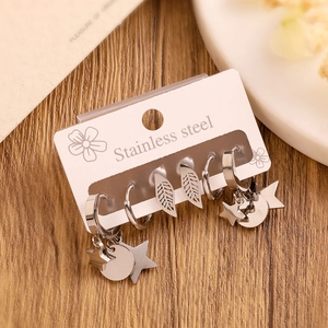 Detail of silver stainless steel earring set with moon, star and leaf charms