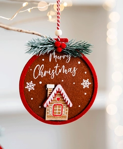 Detail of felt gingerbread house ornament with Merry Christmas text and pine needles