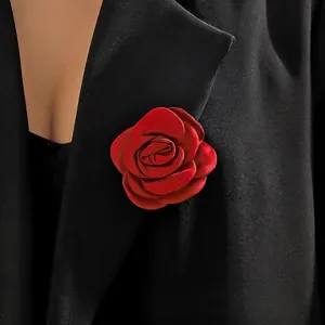 Detail of wine red silk rose brooch pinned on a black suit jacket lapel
