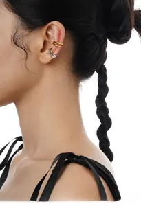 Detail view of double-layer minimalist silver and gold ear cuffs worn on the ear cartilage