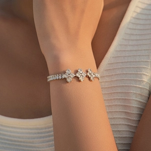 Close-up of 18K plated silver bracelet with sparkling zircon cross-star floral design