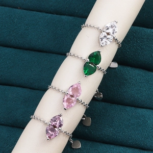 Detail of four colorful heart gemstone chain rings on a jewelry display stand