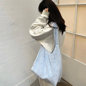 Detail of light blue leopard print plush tote bag with black and white checkered lining