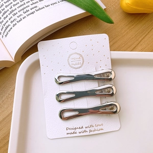 Three silver hollow metal duckbill hair clips presented on a decorative card packaging