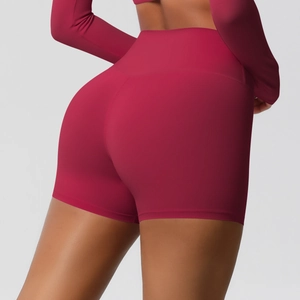 Detail of high-waisted seamless yoga shorts showing peach lift effect in dark rose red