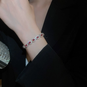 Détail d'un bracelet de luxe avec zircons rouges ovales et halo de diamants