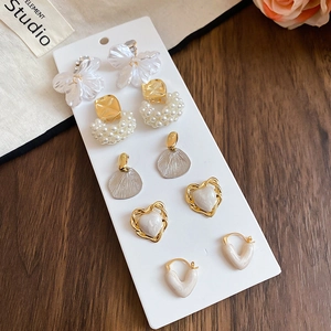 Detail view of 6-pair gold and pearl earring set with floral and heart designs