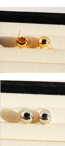 Detailed comparison of minimalist gold and silver teardrop stud earrings on velvet