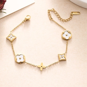Detailed close-up of a gold stainless steel bracelet featuring clover and star motifs