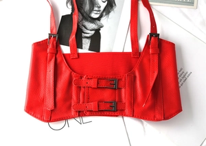 Detail of red PU leather corset belt with adjustable straps and double-breasted buttons