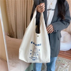 Détail du sac cabas en toile blanche avec motif lapin bleu et fermeture à bouton pression
