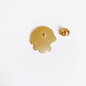 Detail of golden metal pin back with textured surface and secure butterfly clutch