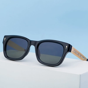 Polarized sunglasses with black frames and vintage engraved gold temples on blue background