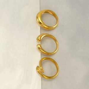 Vue détaillée de trois bagues minimalistes en acier inoxydable plaqué or 18k sur soie