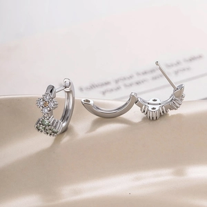 French vintage silver hoop earrings with zircon clover charms on beige silk fabric