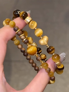 Detailansicht von Tigerauge-Stein und Holzperlen Armband mit goldenem Herzanhänger