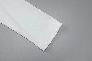 Détail rapproché montrant la texture côtelée et le revers de qualité sur ce haut blanc à manches