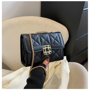 Close-up of black quilted shoulder bag with gold chain strap and vintage square lock