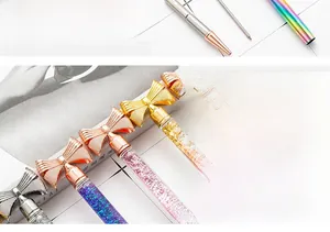Detail showing the elegant metal bow cap and sparkling glitter fill of the pen