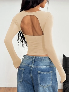 Detail of Y2K beige long sleeve top featuring a large cutout open back design on model