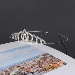 Close-up of elegant silver rhinestone bridal crown on a book with cinematic lighting