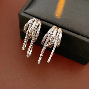 Vue macro de boucles d'oreilles multicouches argentées ornées de zircons brillants