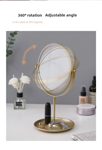 Detailed view of rotating gold vanity mirror with functional jewelry storage tray